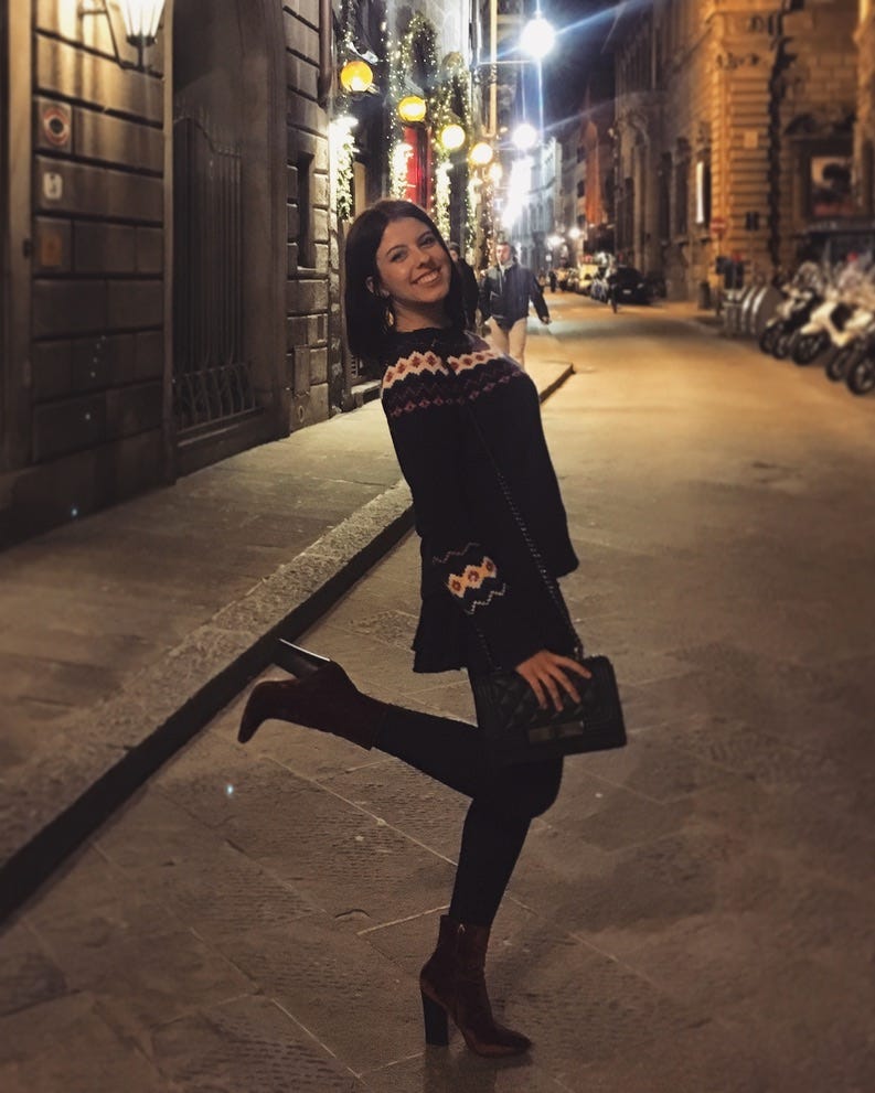 A photo of college Mariya Delano posing on a street in Florence.