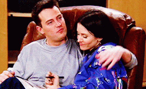 Chandler and Monica from Friends being cute on a chair together.